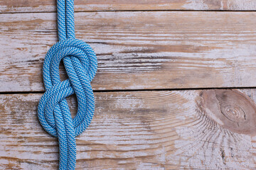 eight knot on a rope on a wooden background. Copy space.