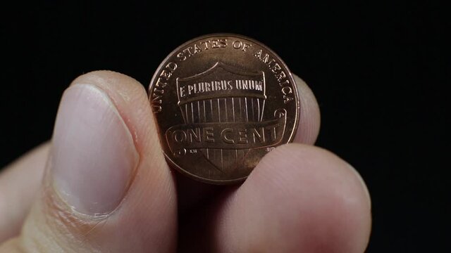 American one cent shining in man hand, close up footage. Macro coins. 