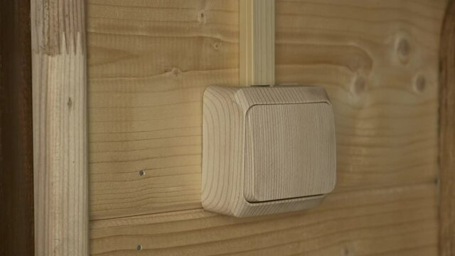 Human Hand Turn On And Turn Off A Power Button On A Wooden Wall.