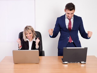 Cheerful and euphoric business staff at seeing good results on the computer