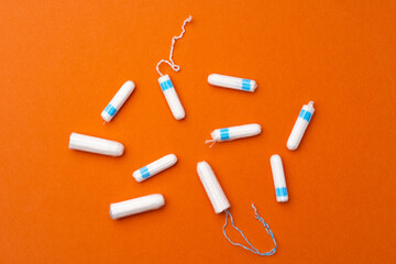 Medical female tampons on orange background top view