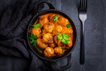 Meatballs with tomato sauce in black pan