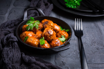 Meatballs with tomato sauce in black pan