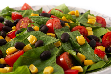 Mexican salad with black beans, corn,tomatoes,lettuce and pepper isolated on white background	