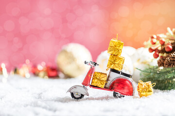 Vintage red toy motorbike with christmas gifts in the snow. Xmas and Happy New Year theme.