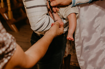 rite of sacrament of epiphany child baby in church. priest blesses child, smears with holy water,...