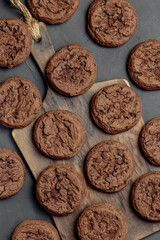 Homemade Baking Desserts Sweet Food, Brownie Round Dark Brown Chocolate Coffee Cookies with fresh Cocoa on a cutting board on a black Background on a Table