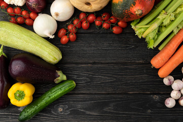 Vegetables on a dark wooden background. Top view. Copy space. Beautifully decorated still life of vegetables.