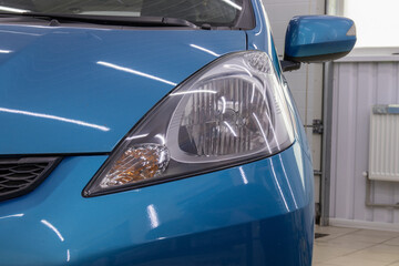 Obraz premium Car headlight after polishing. Car restoration and repair concept. Part of a series.