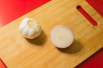 Onion and garlic on a cutting board close-up.