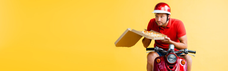 delivery man in helmet riding scooter and holding pizza in box on yellow, banner