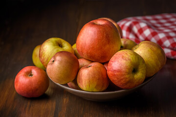 bowl full of apples on a wooden table