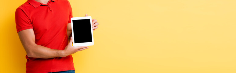 cropped view of man holding digital tablet with blank screen on yellow, banner