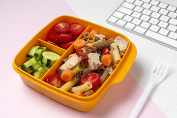 Lunch at workplace healthy pasta with tuna, tomatoes, in lunch box