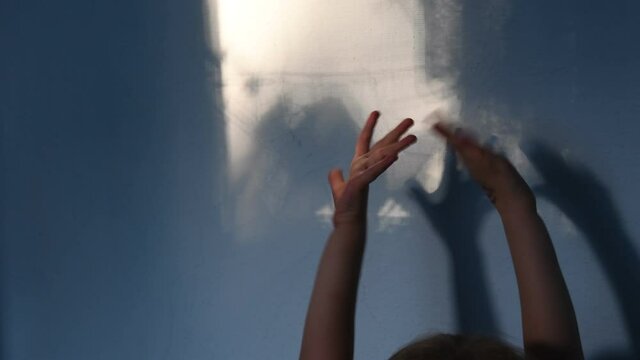 Blur shadows of child hands on wall. Game with light and shadow. Dark spooky silhouettes of hands for Halloween concept