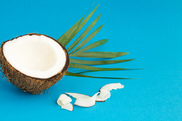 Half coconut and chips on the blue background with copy space