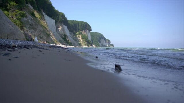 walking on sandy beach with view on chalk cliffs of r&uuml;gen at the jasmund national park