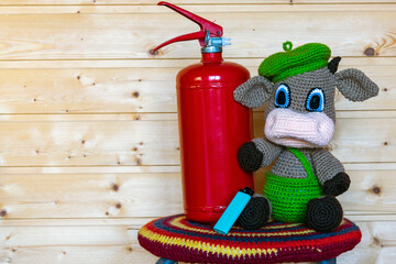Handmade amigurumi doll goby with a fire extinguisher. Background from the board.