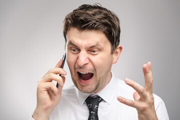 Angry man screaming on client by phone. Aggressive boss calling employee who didn't finish his work on time.
