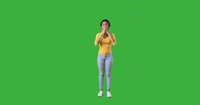 Ecstatic african american woman shouting and celebrating success over green background