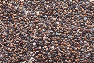 Wall made of sea stones of different colors and sizes