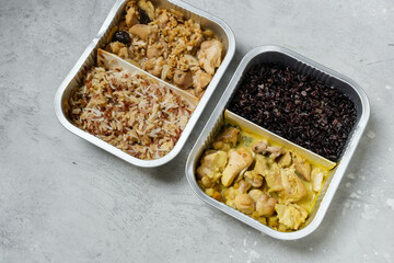 Takeout coronavirus food. Different aluminium lunch box with ravioli, curry chicken rice, gyoza tempura, noodles vegetables, lentils with pumpkin. covid-19 takeaway  food delivery.