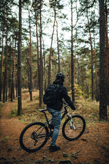 Obraz premium Young man mountainbiker with bicycle along a forest trail, MTB bike ride