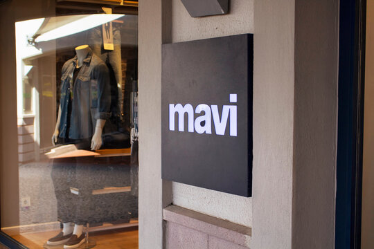 Close up view of famous fashion brand signage and its store window in the background.