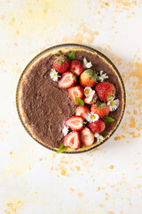 Steam cooked cake decorating with daisies, strawberry and chocolate sauce.