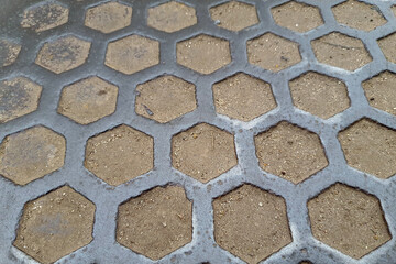 The texture of a metal plate with a pattern of hexagonal cells.