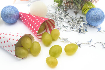 Cones with grapes to celebrate the end of the year with Christmas balls and a garland of stars.