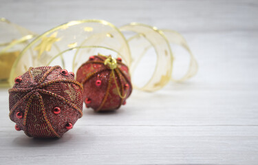 Red Christmas balls decorated with golden laces and red balls.At the bottom garland gold on a light background