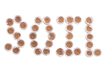 Word soil with peat tablets for seedlings isolated on white background