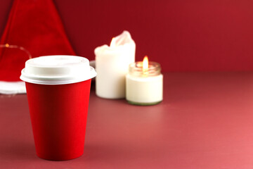 take away red coffee cup to go on red background. Christmas atmosphere, decoration, sales, spend time with friends. Concept holiday, new year, celebration card, space for text