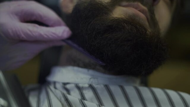 close-up of a man's beard, a trimer removes excess hair