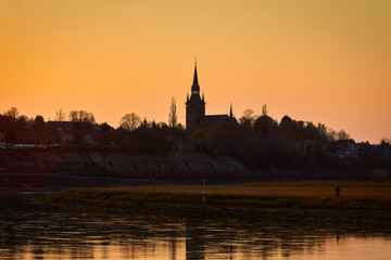 Fototapeta na wymiar silhouette of a church in the city of Cossebaude near Dresden on the river Elbe at sunset in the evening light