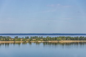 Colorful spring landscape on river with beautiful clouds in the sky