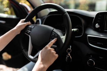 Interior view of a modern new car. Hands of a young woman on the car's wheel.