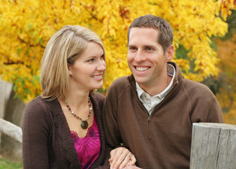 Fototapeta premium attractive couple standing together outdoors against yellow tree background