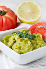 Guacamole sauce with tomato and lemon