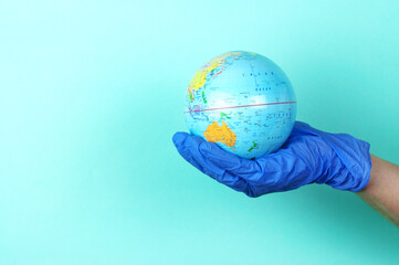 globe in the hands with rubber gloves, the concept of disinfection in the world