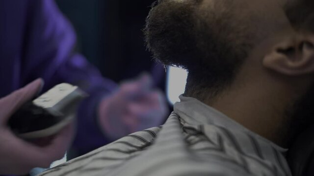 close-up of a man's beard, a barber trimer makes a correction