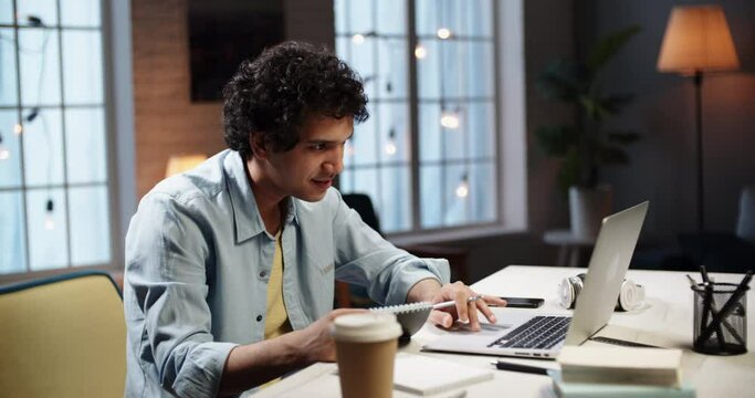 Young asian student doing an assignment research on his computer. Manager surfing web while working on his project from home during self isolation 4k footage