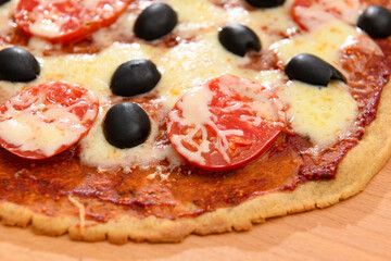homemade pizza, vegetarian food, baked vegetables and cheese, tomatoes and olives, delicious food on a wooden background