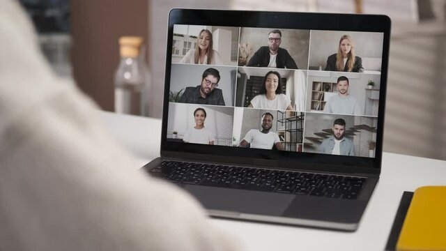 Discussing project online. Over shoulder close up view. Group video call. Remote communication of happy multiracial young people. Working from modern home office. Business chat conference. Closeup 4K