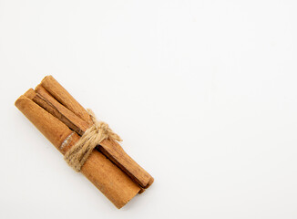 Cinnamon sticks tied with a cord on a white background.