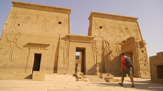 A young man walking towards the Temple of Philae without people, a Greco-Roman construction seen from the river Nile, a temple dedicated to Isis, goddess of love. Aswan. Egyptian
