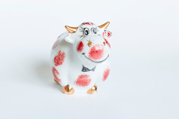 Porcelain bull figurine in white and red color on a white background. New year of the bull