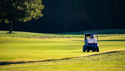 A golf cart on a golf course with a natural light sunset background on a luxury country club golf course. 