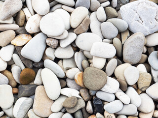 Sea grey and white pebbles or rocks, stones as nature background. Beautiful sea stones of different sizes, colors and texture. Excellent natural concept for interior exterior decoration or any design.